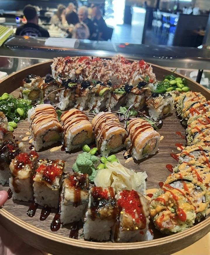 A round wooden platter loaded with Nori's signature rolls and nigiri